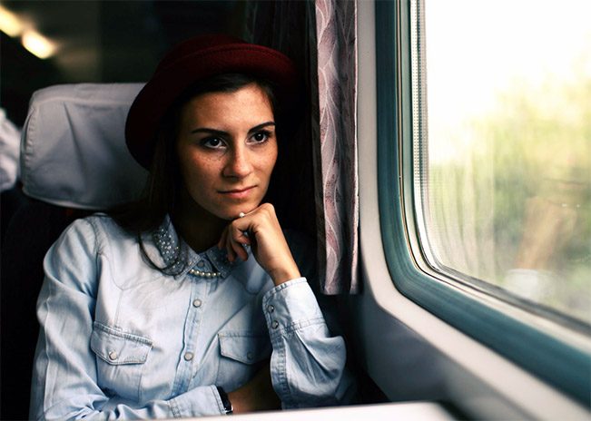 a woman looking outside the window of a train
