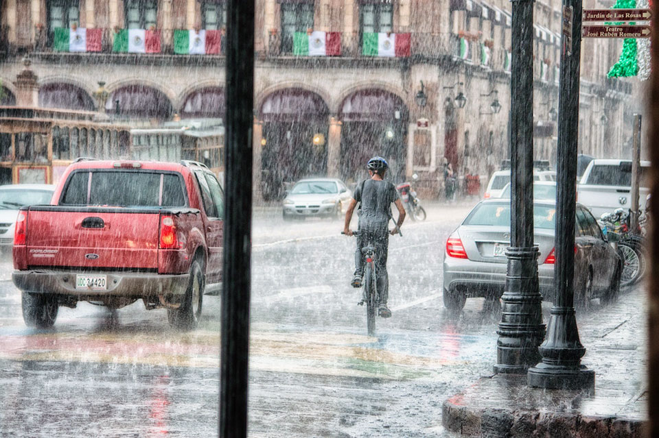 a man biking on a rainy day
